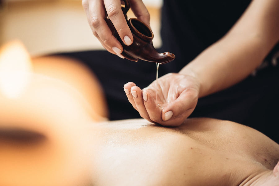 A therapist's hands massaging a guest's back