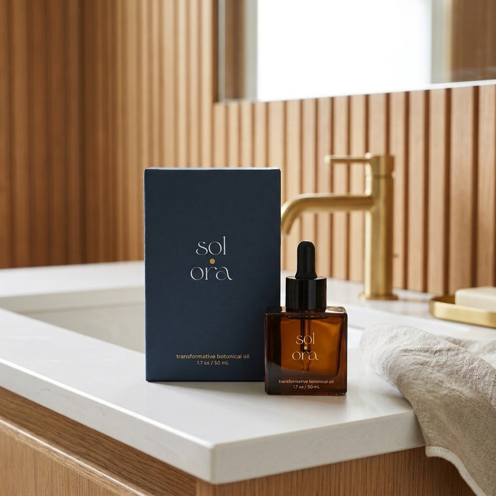 The Sol Ora carton and bottle on a white bathroom counter beside a brass tap