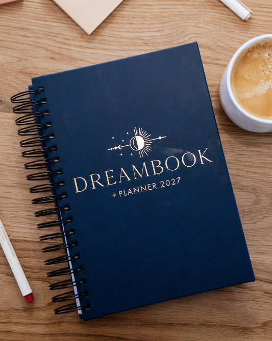 The Nightfall 2027 Dreambook + Planner beside a cup of coffee