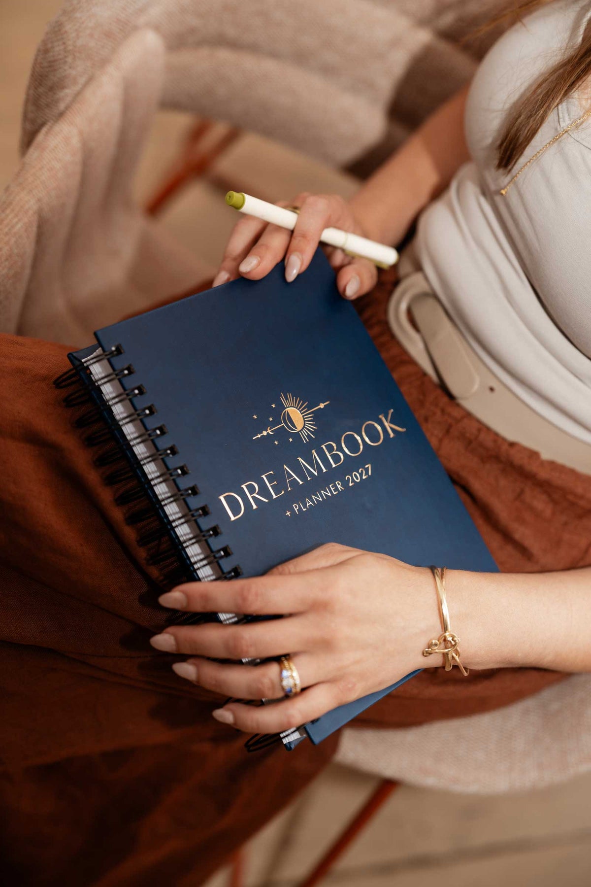 Two hands holding the Dreambook + Planner in Classic Black