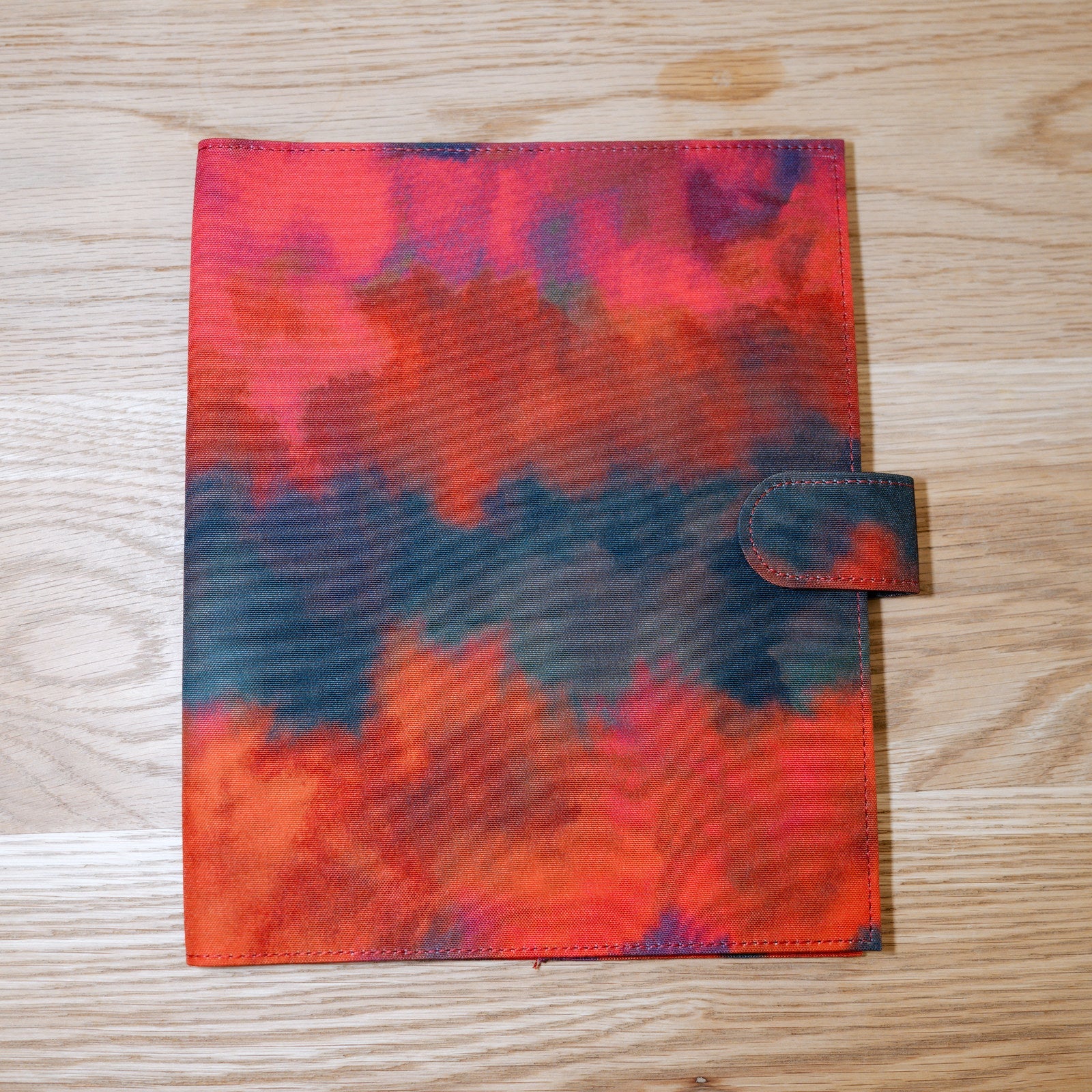 The Ember & Ink cover in watercolor reds and deep blue-black