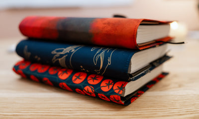 The three new covers stacked on a table