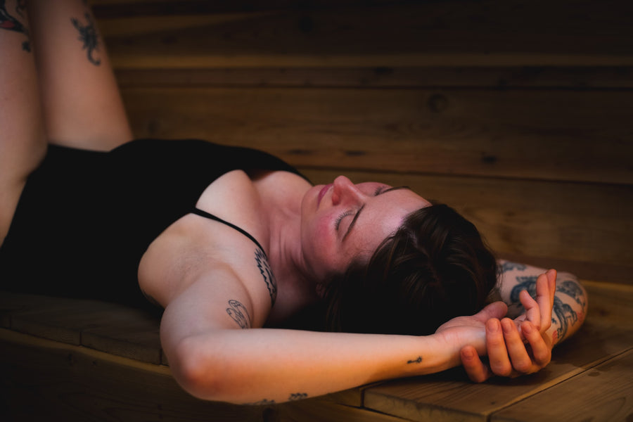 A guest lying back on a bench in the cedar sauna at The Dragontree Sanctuary