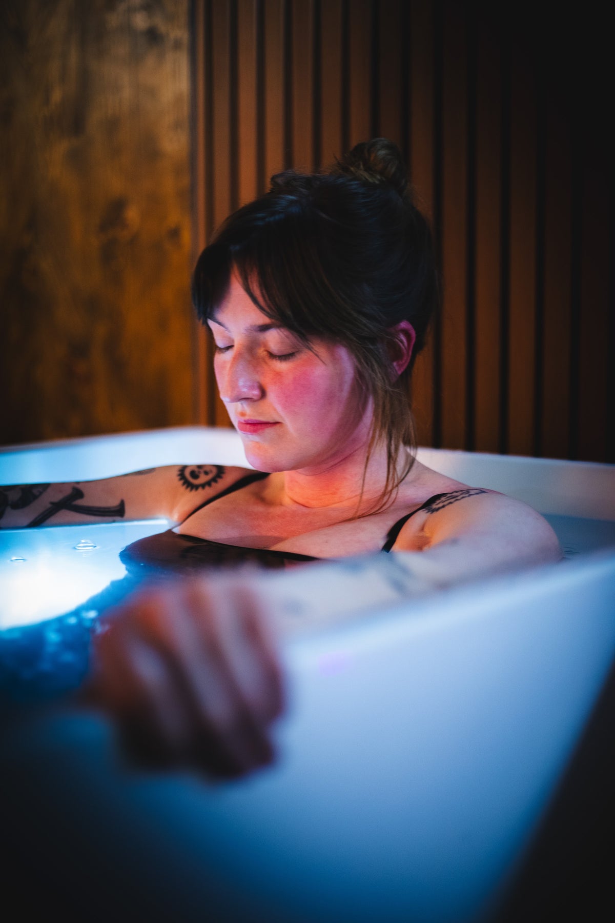 A guest resting in a lit cold plunge at The Dragontree Sanctuary