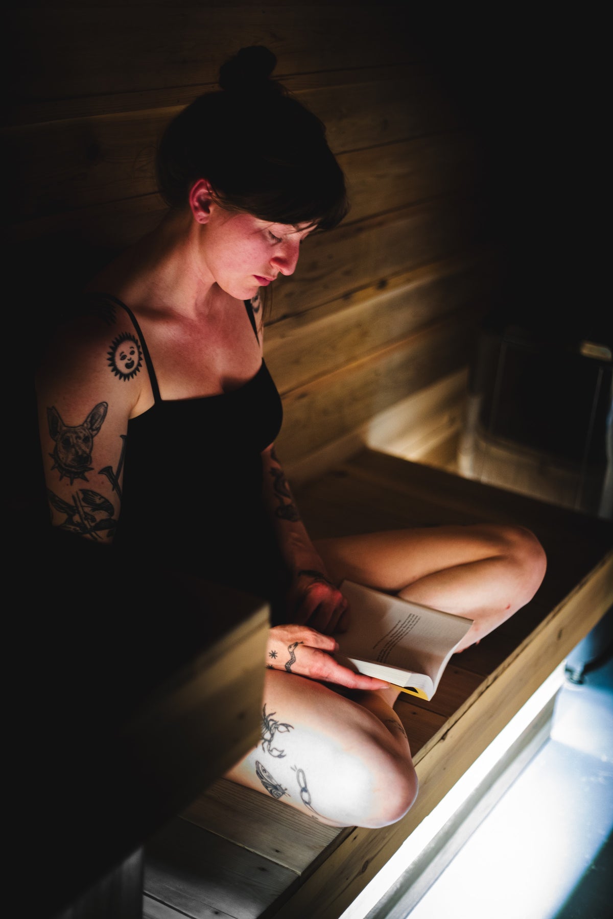 A guest reading on the cedar sauna bench at The Dragontree Sanctuary
